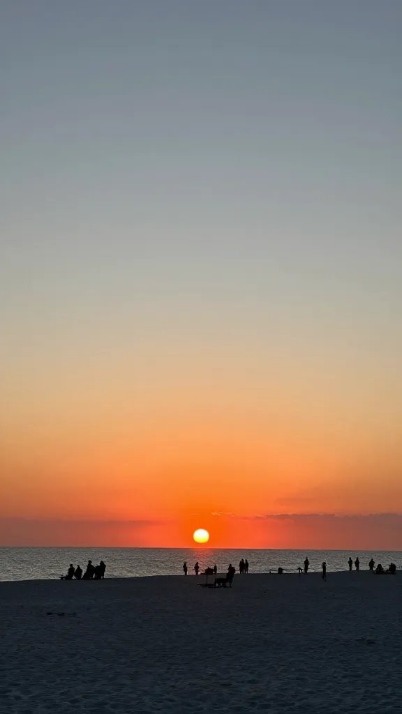 Sunset over Clearwater Beach with silhouettes of vacationers