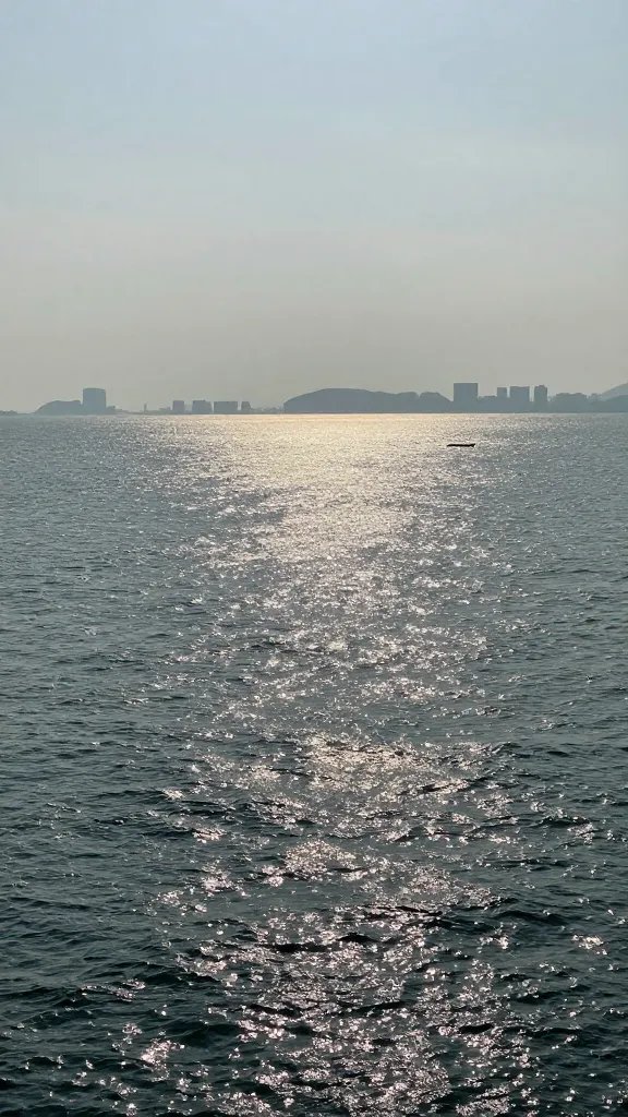 "glassy sea surface, distant distant skyline"